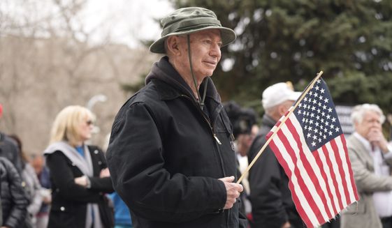 An attendee holds an American flag during a rally calling for free and fair elections in Colorado Tuesday, April 5, 2022, on the west steps of the State Capitol in downtown Denver. (AP Photo/David Zalubowski)