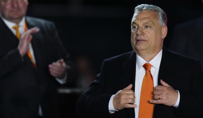 Hungary&#x27;s Prime Minister Viktor Orban acknowledges cheering supporters during an election night rally in Budapest, Hungary, Sunday, April 3, 2022. Early partial results in Hungary&#x27;s national election are showing a strong lead for the right-wing party of pro-Putin nationalist Orban as he seeks a fourth consecutive term. (AP Photo/Petr David Josek)
