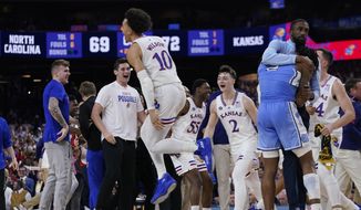 North Carolina guard Caleb Love, right, reacts to a loss as Kansas&#39; Jalen Wilson (10) celebrates after a college basketball game in the finals of the Men&#39;s Final Four NCAA tournament, Monday, April 4, 2022, in New Orleans. Kansas won 72-69. (AP Photo/David J. Phillip) **FILE**
