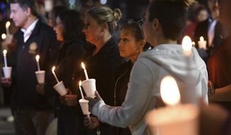 People attend a candlelight vigil for victims of a fatal shooting held at Ali Youssefi Square in Sacramento, Calif., late Monday, April 4, 2022. Multiple people were killed and injured after the shooting that occurred early Sunday. (Jose Carlos Fajardo/Bay Area News Group via AP)