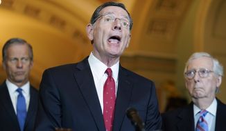 Sen. John Barrasso, R-Wyo., center, speaks to reporters after a Republican strategy meeting at the Capitol in Washington, Tuesday, March 15, 2022. Sen. John Thune, R-S.D., left, and Senate Minority Leader Mitch McConnell, R-Ky., look on. (AP Photo/Mariam Zuhaib)
