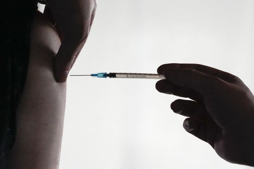 A doctor administers a COVID-19 vaccine to a man, inside the Klunkerkranich restaurant and night club during an ongoing vaccination campaign of the Clubkommission in Berlin, Germany, Wednesday, Jan. 5, 2022. European health officials say its too early to consider giving a fourth dose of the messenger RNA coronavirus vaccines to most people, but say an extra booster can be administered to people over age 80. In a statement on Wednesday, April 6, 2022, the European Medicines Agency and the European Centre for Disease Prevention and Control said they had reviewed data for a fourth dose of the COVID-19 vaccines made by Pfizer-BioNTech and Moderna Inc. (AP Photo/Markus Schreiber, File)