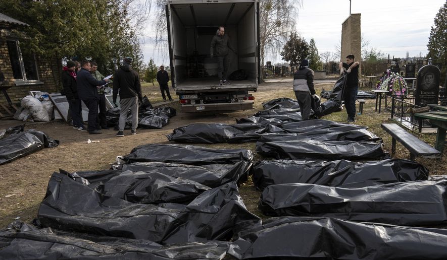 Cemetery workers load the corpses of civilians killed in Bucha into a truck, to be transported to the morgue, on the outskirts of Kyiv, Ukraine, Wednesday, April 6, 2022. (AP Photo/Rodrigo Abd)