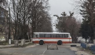 A bus blocks a street in Chernobyl, Ukraine, Tuesday, April 5, 2022. (AP Photo/Oleksandr Ratushniak)