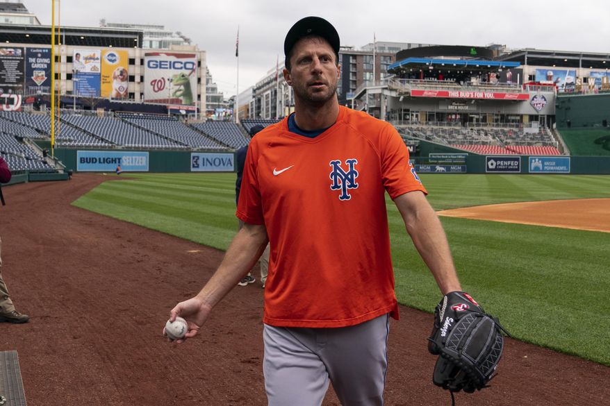 New York Mets starting pitcher Max Scherzer walks off the field after a baseball workout at Nationals Park, Wednesday, April 6, 2022, in Washington. The Washington Nationals and the New York Mets are scheduled to play on opening day, Thursday. (AP Photo/Alex Brandon)