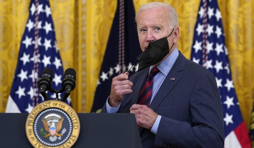 President Joe Biden takes off his mask as he arrives to speak about the coronavirus pandemic in the East Room of the White House in Washington, Tuesday, Aug. 3, 2021.  In the latest Senate package targeted at stopping the coronavirus, U.S. lawmakers dropped nearly all funding for curbing the virus beyond its borders, in a move many health experts describe as dangerously short-sighted. They warn the suspension of COVID aid for poorer countries could ultimately spur the kind of unchecked transmission needed for the next worrisome variant to emerge. (AP Photo/Susan Walsh, File)