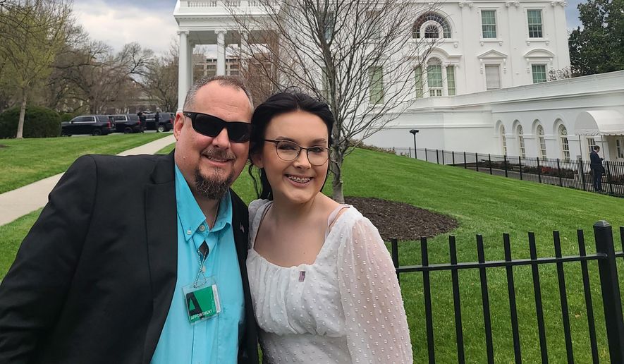 In a photo provided by Jeff Walker, he and his daughter Harleigh of Auburn, Ala., stand outside the White House on March 31, 2022, where they were guests for Transgender Day of Visibility. The family is fighting legislation in Alabama that would outlaw puberty blockers and hormone treatments for trans youth under 19. (Courtesy of Jeff Walker via AP)