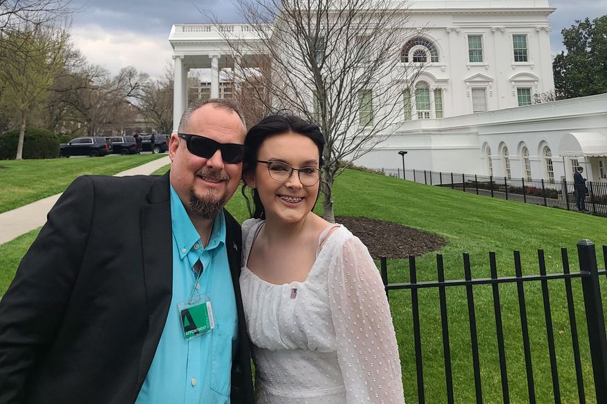 In a photo provided by Jeff Walker, he and his daughter Harleigh of Auburn, Ala., stand outside the White House on March 31, 2022, where they were guests for Transgender Day of Visibility. The family is fighting legislation in Alabama that would outlaw puberty blockers and hormone treatments for trans youth under 19. (Courtesy of Jeff Walker via AP)