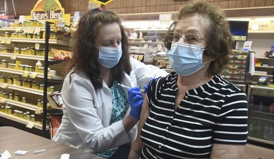 Pharmacist Karen Flynn gives a second Moderna booster shot to her mother Joann Pangonis, of New Boston, Pa., at Morris Drug in Mahanoy City, Pa., on Friday, April 1, 2022. (Jacqueline Dormer/Republican-Herald via AP) ** FILE **