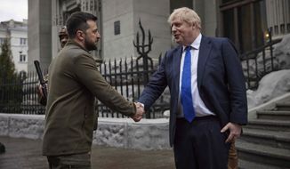 In this image provided by the Ukrainian Presidential Press Office, Ukrainian President Volodymyr Zelenskyy, left, and Britain&#x27;s Prime Minister Boris Johnson, shake hands during their walk in downtown Kyiv, Ukraine, Saturday, April 9, 2022. (Ukrainian Presidential Press Office via AP)