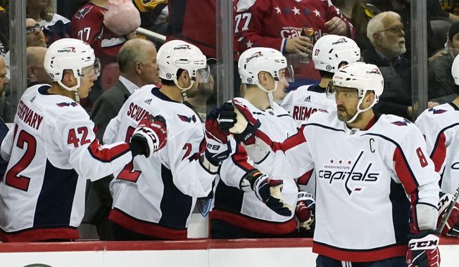 Washington Capitals&#x27; Alex Ovechkin (8) is greeted by teammates on the bench after scoring a power play goal against the Pittsburgh Penguins during the second period of an NHL hockey game, Saturday, April 9, 2022, in Pittsburgh. (AP Photo/Keith Srakocic)