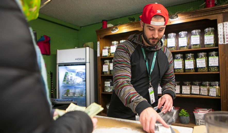 Jed Sadloski, right, helps customer Kate Porte at Lionheart Cannabis in Billings, Mont., during the opening day of legal recreational marijuana sales in Montana on Jan. 1, 2022. Recreational cannabis sales have totaled more than $43.5 million so far this year, setting Montana on track to reach $174 million by the of the year. (Ryan Berry/The Billings Gazette via AP)