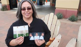 Carmen Briones holds up photos of her husband, Riley Briones Jr., who is serving life in prison, on Feb. 22, 2022, in Anthem, Ariz. Riley Briones&#39; attorneys are asking a federal appeals court for another chance to argue his sentence should be cut short based on improvements he&#39;s made behind bars since being convicted in the 1994 death of Brian Patrick Lindsay when Briones was 17. (AP Photo/Felicia Fonseca)