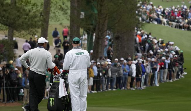 Tiger Woods waits with his caddie Joe LaCava to hit on the second fairway during the third round at the Masters golf tournament on Saturday, April 9, 2022, in Augusta, Ga. (AP Photo/Charlie Riedel)