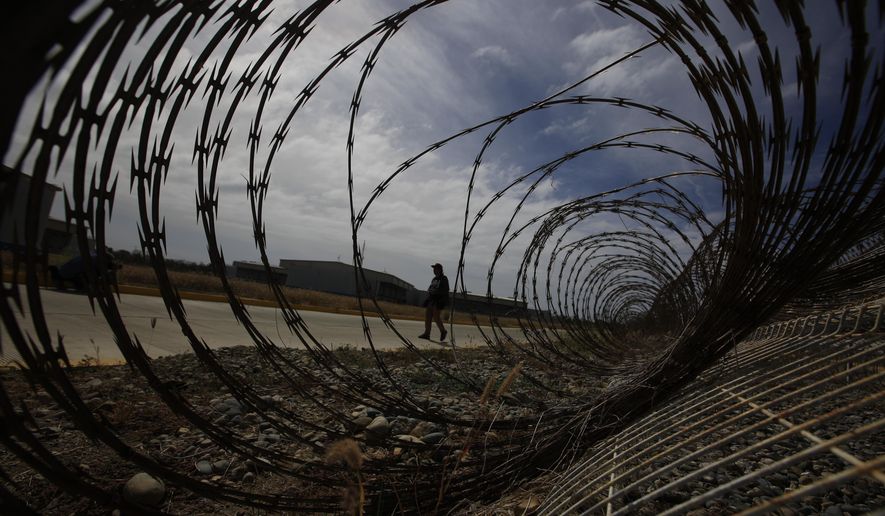 FILE - A journalist walks past a fallen section of fencing during a media tour of the now closed Laguna del Toro maximum security facility on the former Islas Marias penal colony located off Mexico&#39;s Pacific coast, Saturday, March 16, 2019. President Andrés Manuel López Obrador had the facility converted into an environmental education center. Now the government wants to make it an ecotourism destination where visitors can watch sea birds and enjoy the beaches. (AP Photo/Rebecca Blackwell, File)