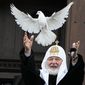 Russian Orthodox Church Patriarch Kirill releases a bird celebrating the Annunciation preceding the celebration of Orthodox Easter in front of the Christ the Savior Cathedral in Moscow, Russia, Thursday, April 7, 2022. (AP Photo/Alexander Zemlianichenko)