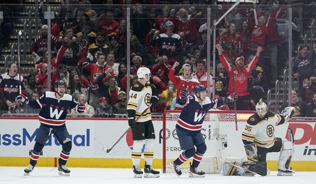 Washington Capitals center Evgeny Kuznetsov, far left, and defenseman Martin Fehervary, center, right, react after teammate John Carlson scored a goal against the Boston Bruins during the second period of an NHL hockey game, Sunday, April 10, 2022, in Washington. Looking on are Boston Bruins&#x27; Josh Brown (44) and goaltender Linus Ullmark (35). (AP Photo/Julio Cortez)