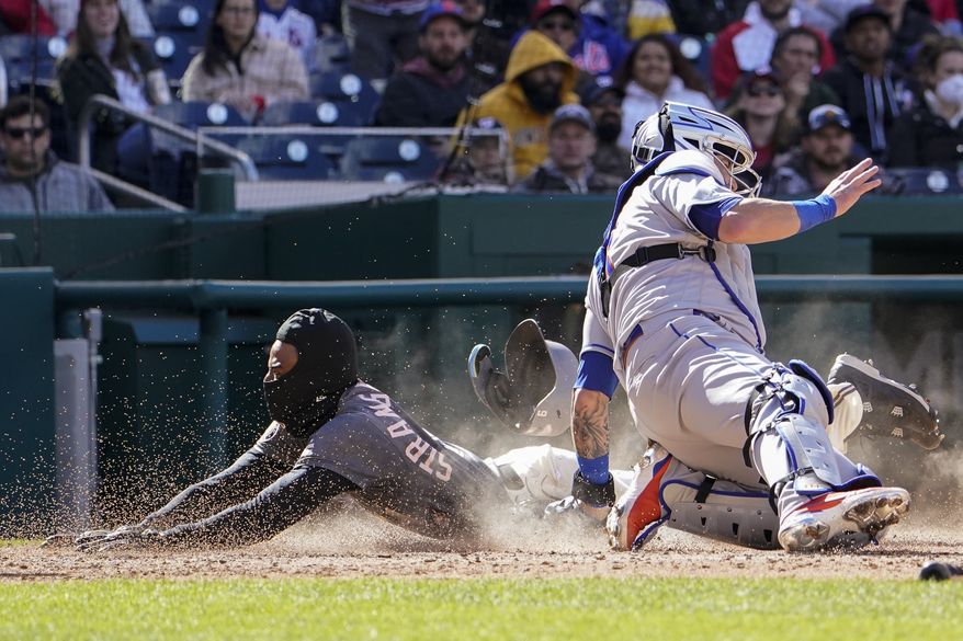 New York Mets catcher Tomas Nido can&#39;t tag Washington Nationals&#39; Dee Strange-Gordon as he scores on a bunt by Washington Nationals&#39; Lucius Fox during the eighth inning of a baseball game at Nationals Park, Sunday, April 10, 2022, in Washington, D.C. (AP Photo/Alex Brandon)