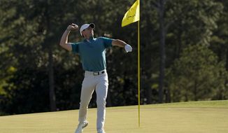 Rory McIlroy, of Northern Ireland, throws his ball to the gallery on the 18th green during the final round at the Masters golf tournament on Sunday, April 10, 2022, in Augusta, Ga. (AP Photo/David J. Phillip)