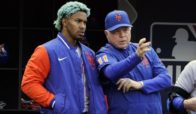 New York Mets&#x27; Francisco Lindor, left, listens as manager Buck Showalter (11) talks during the fourth inning of a baseball game against the Washington Nationals at Nationals Park, Sunday, April 10, 2022, in Washington. (AP Photo/Alex Brandon)