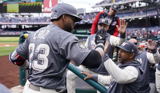 Washington Nationals designated hitter Nelson Cruz celebrates his solo home run with manager Dave Martinez during the first inning of a baseball game against the New York Mets at Nationals Park, Sunday, April 10, 2022, in Washington, D.C. (AP Photo/Alex Brandon)