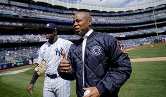 New York City Mayor Eric Adams stands on the field with New York Yankees starting pitcher Luis Severino, left, before the Yankees opening day baseball game against the Boston Red Sox, Friday, April 8, 2022, in New York. (AP Photo/John Minchillo)