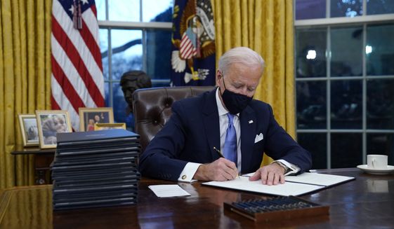 In this Jan. 20, 2021, file photo, President Joe Biden signs his first executive order in the Oval Office of the White House in Washington. Biden laid out an ambitious agenda for his first 100 days in office, promising swift action on everything from climate change to immigration reform to the coronavirus pandemic. Key members of the White House Environmental Justice Advisory Council say one year into the Biden Administration&#39;s commitment that 40% of all benefits from climate investment go to disenfranchised communities, not enough has been done. (AP Photo/Evan Vucci, File)