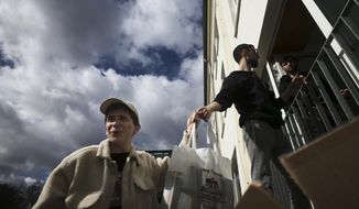 From left, Danya, 21, Gabriel, 21 and Borden, 17 all refugees from Odesa, Ukraine help to deliver bags with food to needy people during preparations for the celebration of Jewish Passover at the Chabad Jewish Education Center in Berlin, Germany, Thursday, April 7, 2022. Rabbis and Jewish organizations are working round the clock within Ukraine, Eastern Europe and other parts of Europe to make sure that Jews who remain in Ukraine and refugees who have fled as far away as Israel are able to celebrate Passover. (AP Photo/Markus Schreiber)