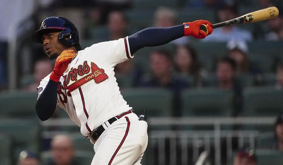 Atlanta Braves&#39; Ozzie Albies follows through on a two-run double during the second inning of the team&#39;s baseball game against the Washington Nationals on Tuesday, April 12, 2022, in Atlanta. (AP Photo/John Bazemore)