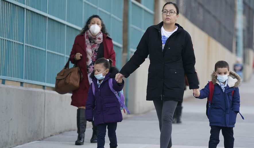Children and their caregivers arrive for school in New York, Monday, March 7, 2022. The Biden administration will extend for two weeks the nationwide mask requirement for public transit as it monitors an uptick in COVID-19 cases. The Centers for Disease Control and Prevention was set to extend the order, which was to expire on April 18, by two weeks to monitor for any observable increase in severe virus outcomes as cases rise in parts of the country. (AP Photo/Seth Wenig) **FILE**