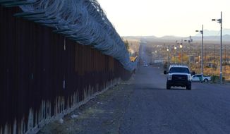 A U.S. Border Patrol vehicle drives along the border fence at the U.S.-Mexico border wall, on Dec. 15, 2020, in Douglas, Ariz. (AP Photo/Ross D. Franklin,File)