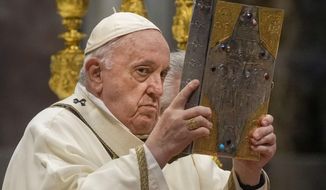 Pope Francis hoists the Gospel book during a Chrism Mass inside St. Peter&#39;s Basilica, at the Vatican, Thursday, April 14, 2022. During the mass the Pontiff blesses a token amount of oil that will be used to administer the sacraments for the year. (AP Photo/Gregorio Borgia)