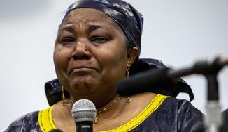 Patrick Lyoya&#39;s mother Dorcas Lyoya sheds tears during a news conference at the Renaissance Church of God in Christ Family Life Center in Grand Rapids, Mich. on Thursday, April 14, 2022. Civil rights attorney Ben Crump is representing the family of Patrick Lyoya, who was shot and killed by a GRPD officer on April 4. (Cory Morse/The Grand Rapids Press via AP)