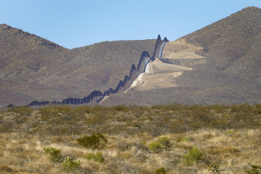 Newly erected border wall separating Mexico, left, and the United States, cuts through through the Sonoran Desert just west of the San Bernardino National Wildlife Refuge, Wednesday, Dec. 9, 2020, in Douglas, Ariz. (AP Photo/Matt York,File)