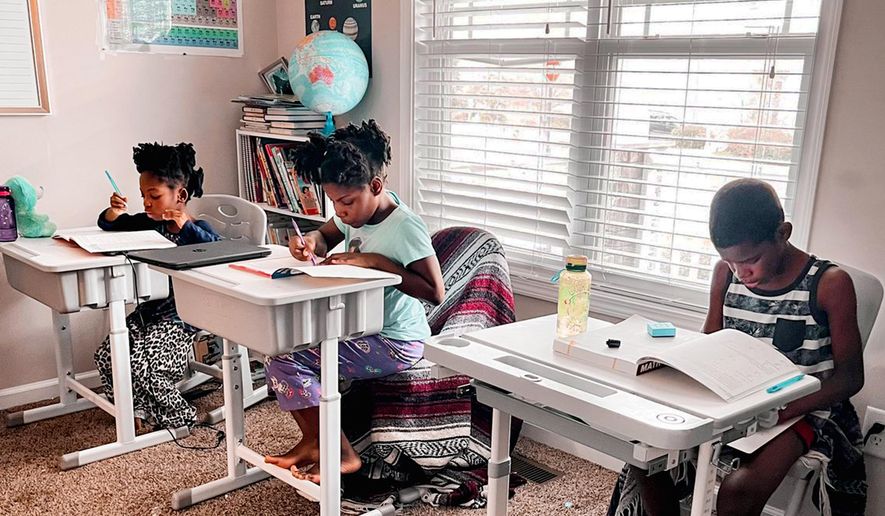 In this undated photo provided by Dalaine Bradley, Drew Waller, 7, Zion Waller, 10, and Ahmad Waller, 11, left to right, study during homeschooling, in Raleigh, N.C. (Courtesy of Dalaine Bradley via AP)