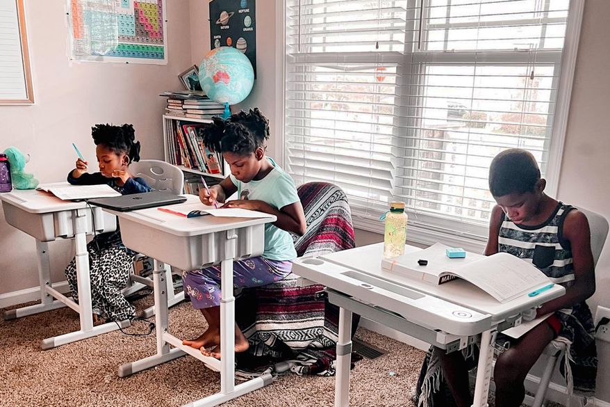 In this undated photo provided by Dalaine Bradley, Drew Waller, 7, Zion Waller, 10, and Ahmad Waller, 11, left to right, study during homeschooling, in Raleigh, N.C. (Courtesy of Dalaine Bradley via AP)