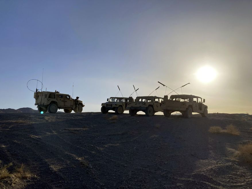 Army vehicles on the ridge, as soldiers from the 2nd Brigade, 1st Cavalry Division, prepare to attack the enemy in the town nearby, during an early morning training exercise at the National Training Center at Fort Irwin, Calif., on April 12, 2022. (AP Photo/Lolita C. Baldor) **FILE**