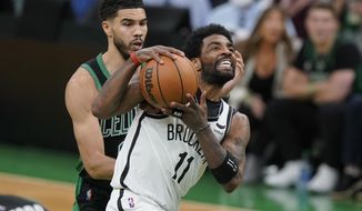 Brooklyn Nets guard Kyrie Irving (11) drives toward the basket as Boston Celtics forward Jayson Tatum (0) defends in the second half of Game 1 of an NBA basketball first-round Eastern Conference playoff series, Sunday, April 17, 2022, in Boston. The Celtics won 115-114. (AP Photo/Steven Senne)
