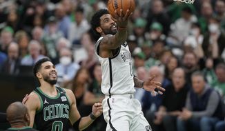 Brooklyn Nets guard Kyrie Irving (11) drives to the basket as Boston Celtics forward Jayson Tatum (0) looks on in the second half of Game 1 of an NBA basketball first-round Eastern Conference playoff series, Sunday, April 17, 2022, in Boston. The Celtics won 115-114. (AP Photo/Steven Senne)