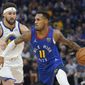 Denver Nuggets guard Monte Morris, right, drives to the basket against Golden State Warriors guard Klay Thompson during the first half of Game 2 of an NBA basketball first-round playoff series in San Francisco, Monday, April 18, 2022. (AP Photo/Jeff Chiu)
