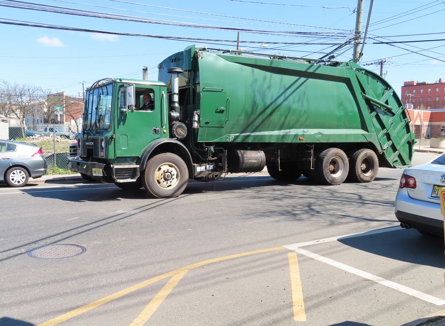 A garbage truck drives down a street in the Ironbound section of Newark, N.J., on Wednesday, April 20, 2022. (AP Photo/Wayne Parry) **FILE**