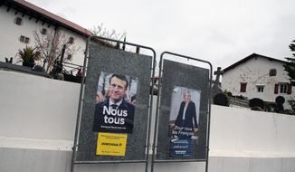 Presidential campaign posters of French President and centrist candidate for reelection Emmanuel Macron and French far-right presidential candidate Marine Le Pen in Arbonne, southwestern France, Tuesday, April 19, 2022. French President Emmanuel Macron is facing off against far-right challenger Marine Le Pen in France&#x27;s April 24 presidential runoff. (AP Photo/Bob Edme)