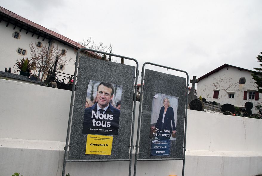 Presidential campaign posters of French President and centrist candidate for reelection Emmanuel Macron and French far-right presidential candidate Marine Le Pen in Arbonne, southwestern France, Tuesday, April 19, 2022. French President Emmanuel Macron is facing off against far-right challenger Marine Le Pen in France&#39;s April 24 presidential runoff. (AP Photo/Bob Edme)