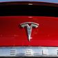 In this Feb. 2, 2020, file photo, the company logo appears on an unsold 2020 Model X at a Tesla dealership in Littleton, Colo. Tesla reported Wednesday, April 20, 2022, that its first-quarter net earnings were over seven times greater than a year ago, powered by strong sales despite global supply chain kinks and pandemic-related production cuts in China. (AP Photo/David Zalubowski, File)