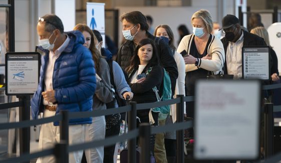 Passengers wait in line at the security checkpoint at Ronald Reagan Washington National Airport, Tuesday, April 19, 2022, in Arlington, Va. (AP Photo/Evan Vucci)