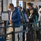 Passengers wait in line at the security checkpoint at Ronald Reagan Washington National Airport, Tuesday, April 19, 2022, in Arlington, Va. (AP Photo/Evan Vucci)
