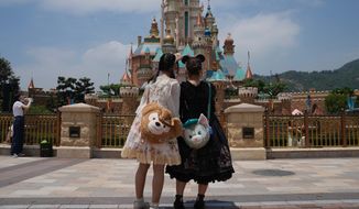 Visitors take photos at the Hong Kong Disneyland, Thursday, April 21, 2022. Hong Kong Disneyland reopened to the public after shutting down due to a surge in COVID-19 infections. (AP Photo/Kin Cheung)