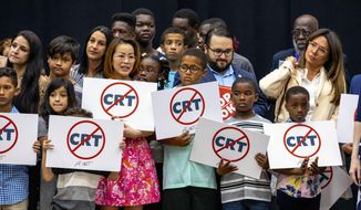 Kids holding signs against critical race theory stand on stage near Florida Gov. Ron DeSantis as he addresses the crowd before publicly signing HB7, &amp;quot;individual freedom,&amp;quot; also dubbed the &amp;quot;stop woke&amp;quot; bill during a news conference at Mater Academy Charter Middle/High School in Hialeah Gardens, Fla., on Friday, April 22, 2022. DeSantis also signed two other bills into laws including one regarding the &amp;quot;big tech&amp;quot; bill signed last year but set aside due to a court ruling, and the special districts bill, which relates to the Reedy Creek Improvement District. (Daniel A. Varela/Miami Herald via AP)