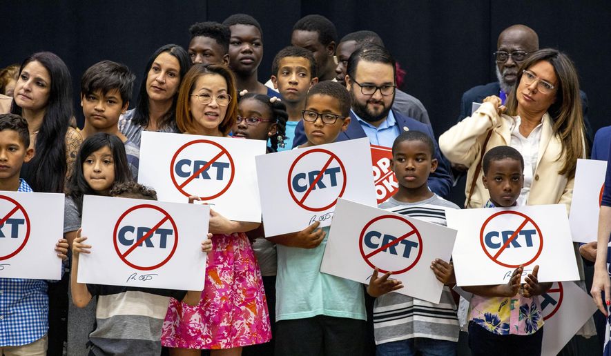 Kids holding signs against critical race theory stand on stage near Florida Gov. Ron DeSantis as he addresses the crowd before publicly signing HB7, &amp;quot;individual freedom,&amp;quot; also dubbed the &amp;quot;stop woke&amp;quot; bill during a news conference at Mater Academy Charter Middle/High School in Hialeah Gardens, Fla., on Friday, April 22, 2022. DeSantis also signed two other bills into laws including one regarding the &amp;quot;big tech&amp;quot; bill signed last year but set aside due to a court ruling, and the special districts bill, which relates to the Reedy Creek Improvement District. (Daniel A. Varela/Miami Herald via AP) ** FILE **