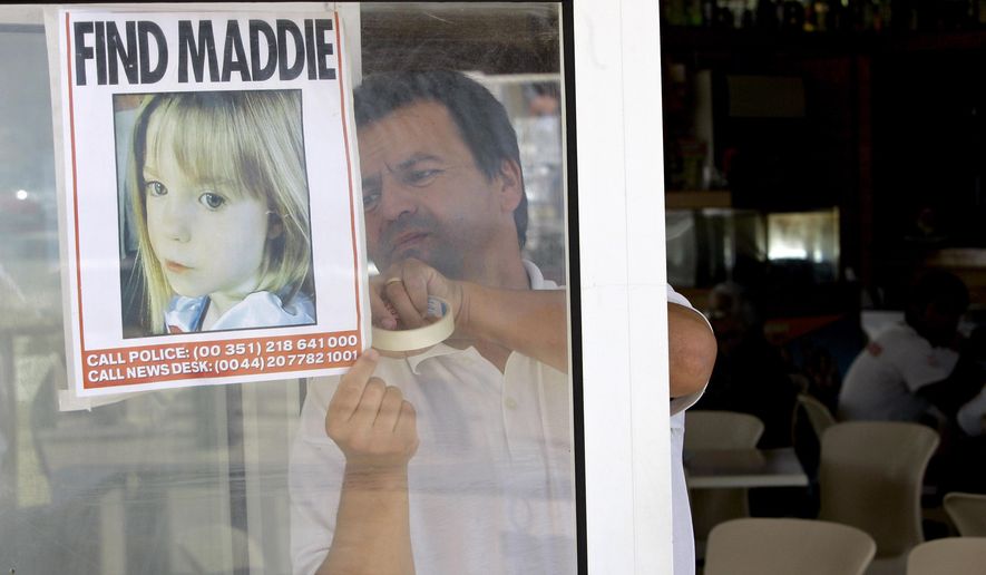 A waiter hangs a picture of missing 3-year-old girl Madeleine McCann on a restaurant&#39;s window, Thursday, May 10 2007, in Praia da Luz, southern Portugal. (AP Photo/Armando Franca, File)